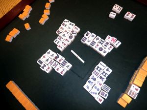 Jemand zieht einen Mahjongstein von der Mauer